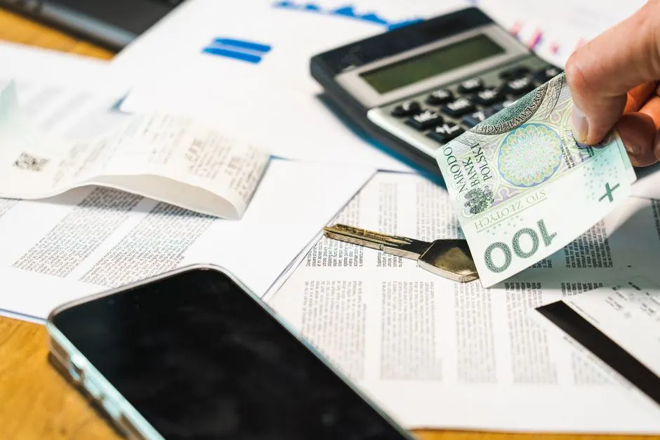 Dirigeant de PME examinant des factures et un contrat d'affacturage sur son bureau